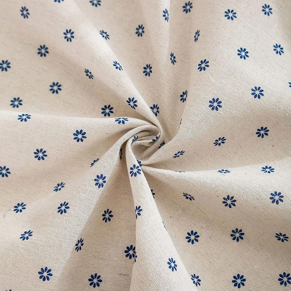 Beige fabric with small, dark blue flower patterns, gathered at the center, creating a spiral effect. The floral design is evenly distributed across the fabric.