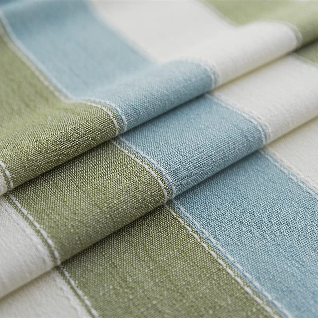 Close-up of a fabric with horizontal stripes in shades of green, blue, and white. The texture shows detailed stitching, emphasizing the woven pattern. The fabric is slightly folded, displaying its thickness and quality.