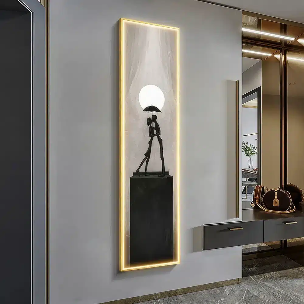 Illuminated wall art featuring a silhouette of a person under an umbrella, standing on a pedestal. The artwork is framed with soft lighting and hangs in a modern interior with reflective surfaces and contemporary decor.