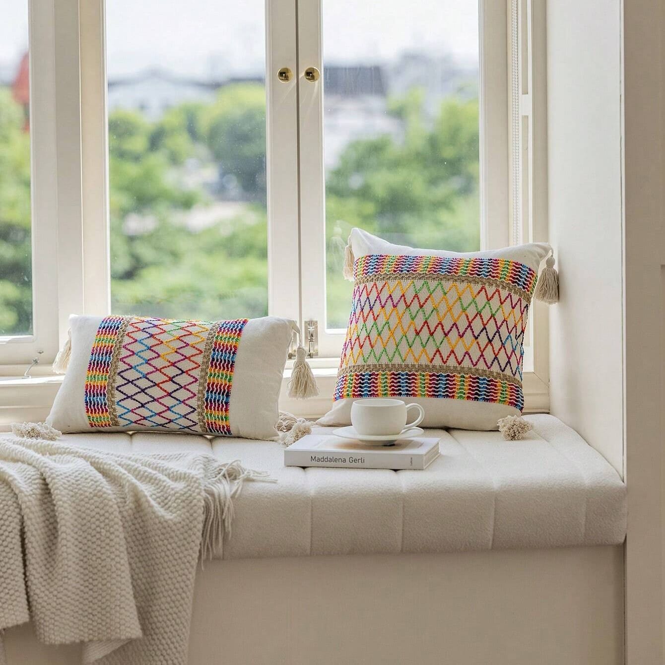 pillows on a bench next to a window