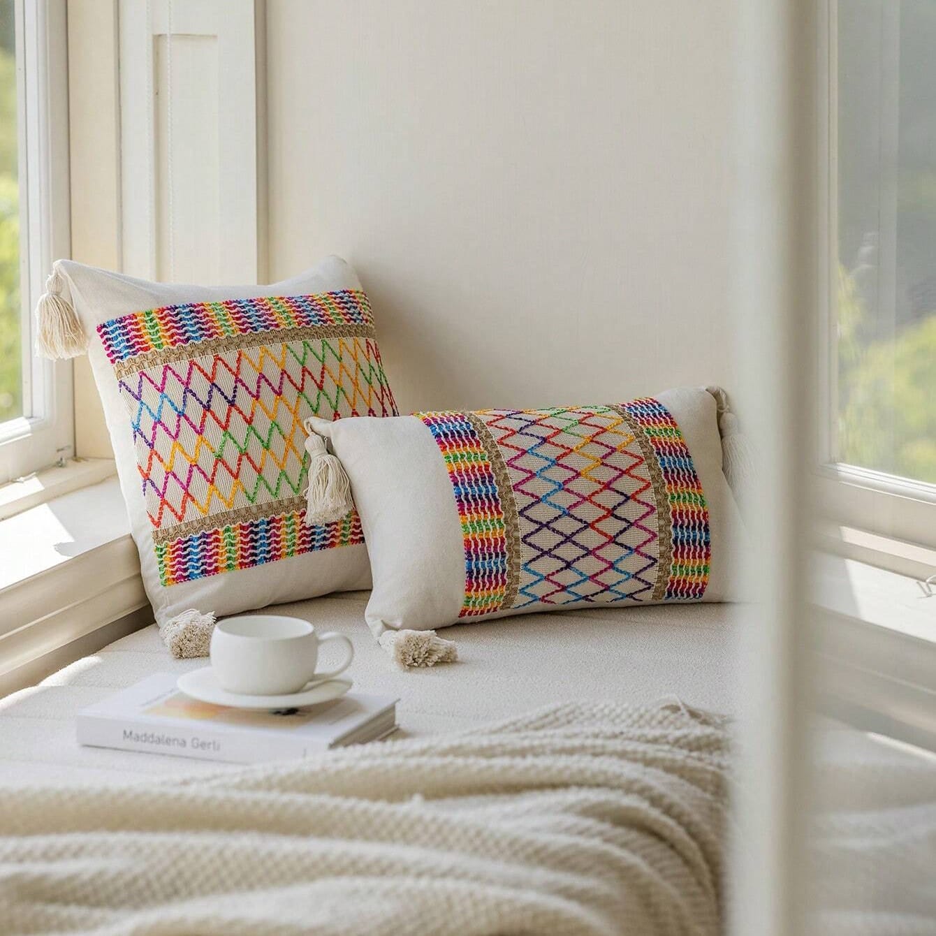 pillows on a bed by a window